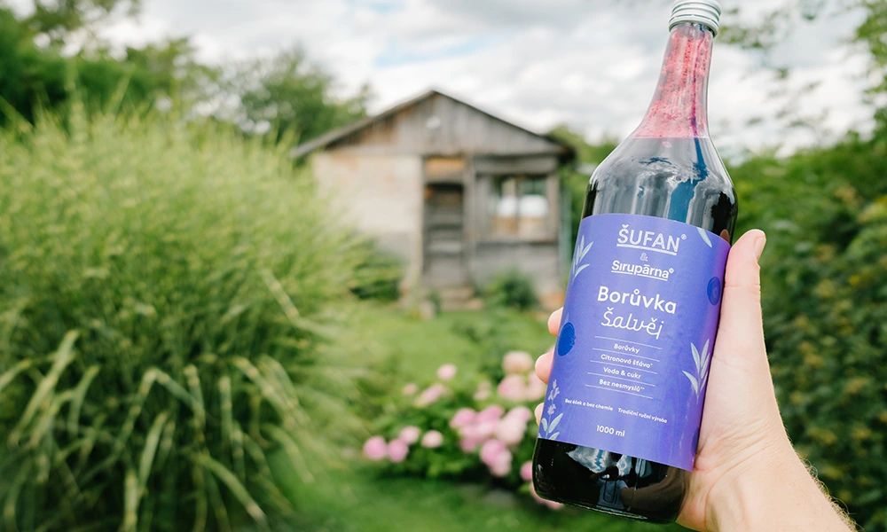Borůvkový sirup se šalvějí Šufan & Sirupárna – lahev sirupu na letní zahradě